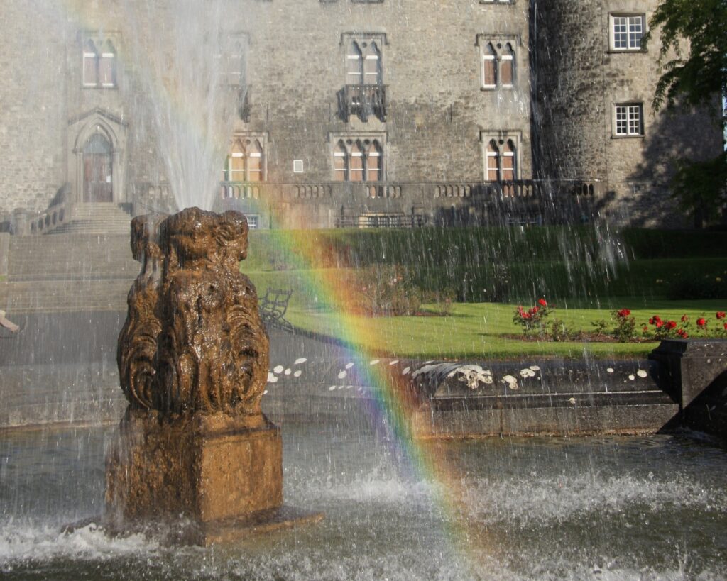 photo of rainbow showing through mist on a fountain