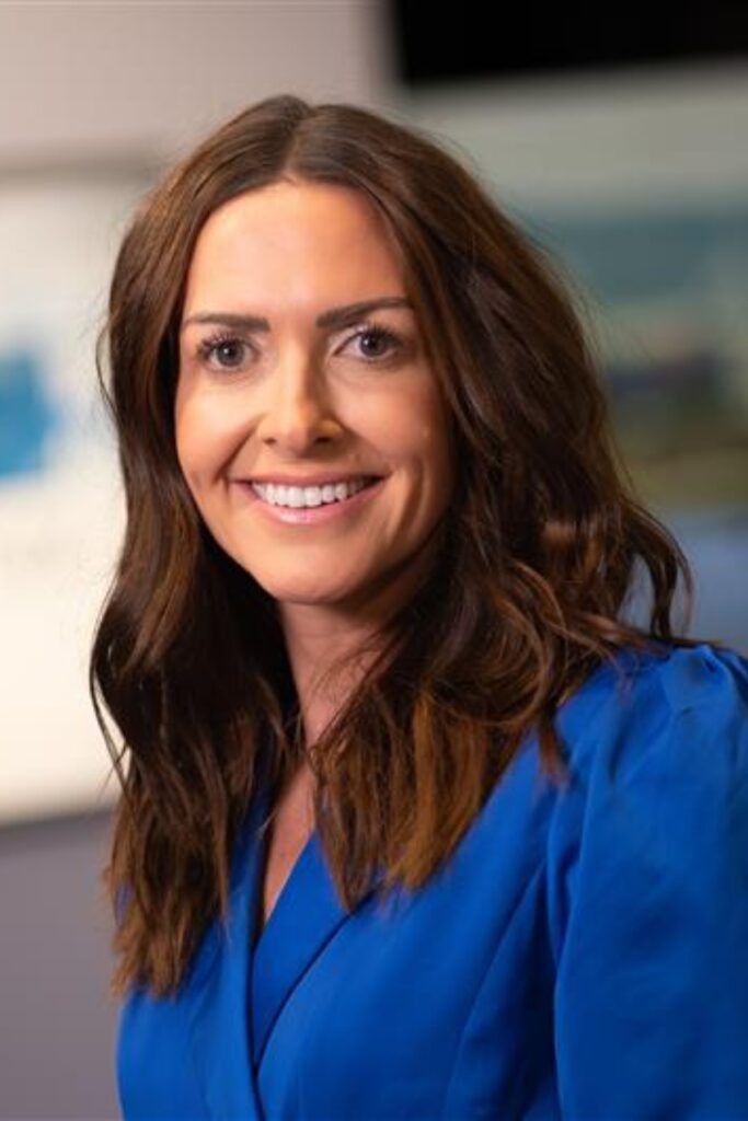 Kate Lewis ITV news reporter facing the camera, smiling,wearing a royal blue blazer