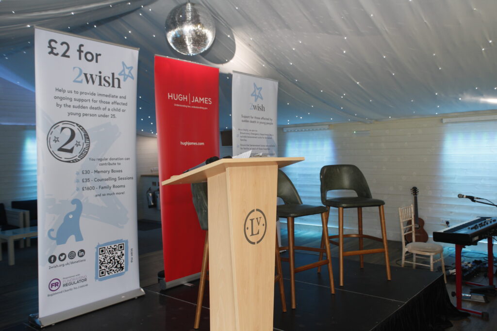 2wish roller banenrs displayed, with hugh james banner inbetween, positioned behind wooden podium displaying llanerch vineyard logo