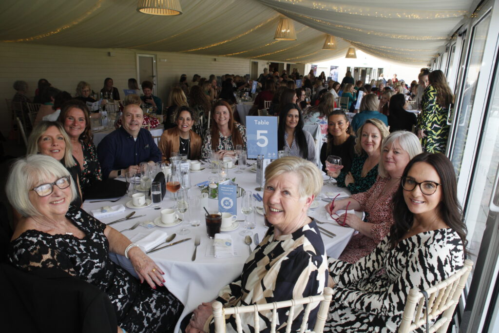 group photo of guests on table five, smiling at camera