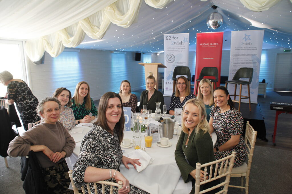 hugh james staff and guests sat round table smiling at camera