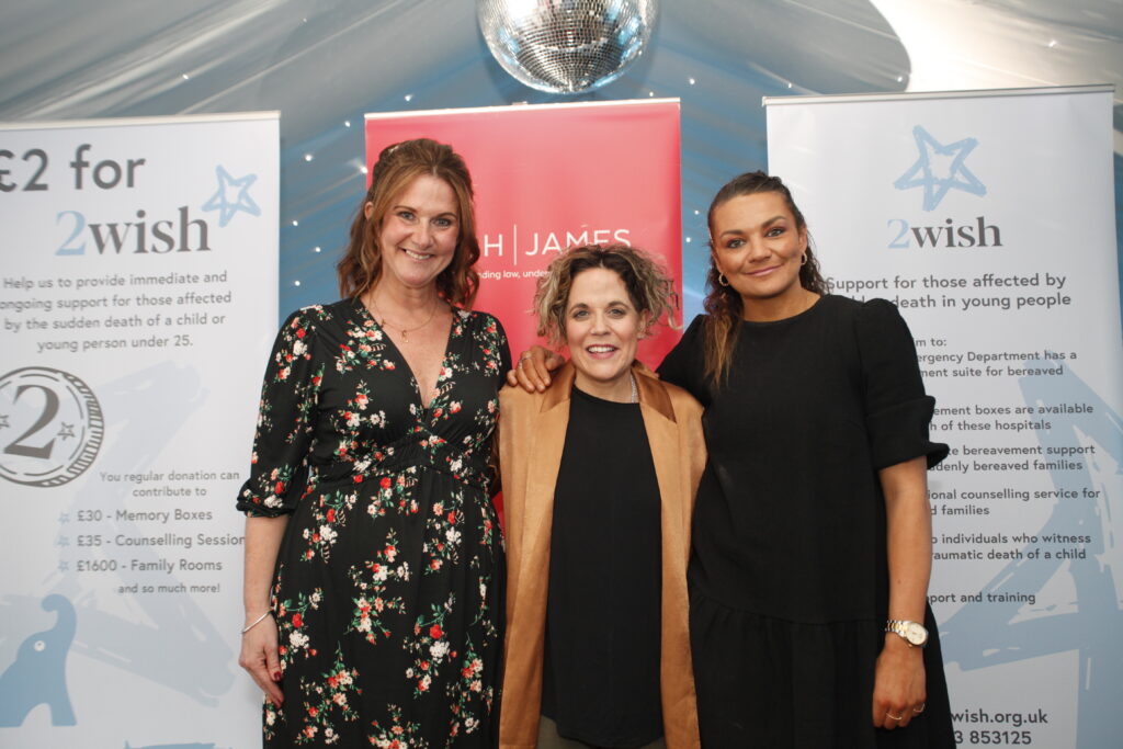 rhian mannings, amty wadge and nia jones stood infront of roller banners smiling at camera