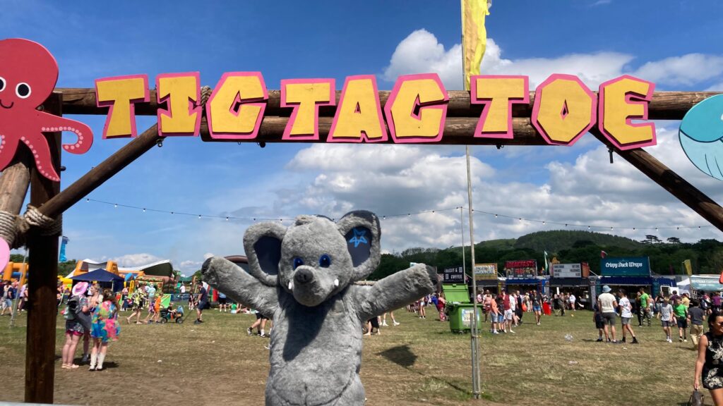 gorgeous george mascot standing under tic tac toe sign