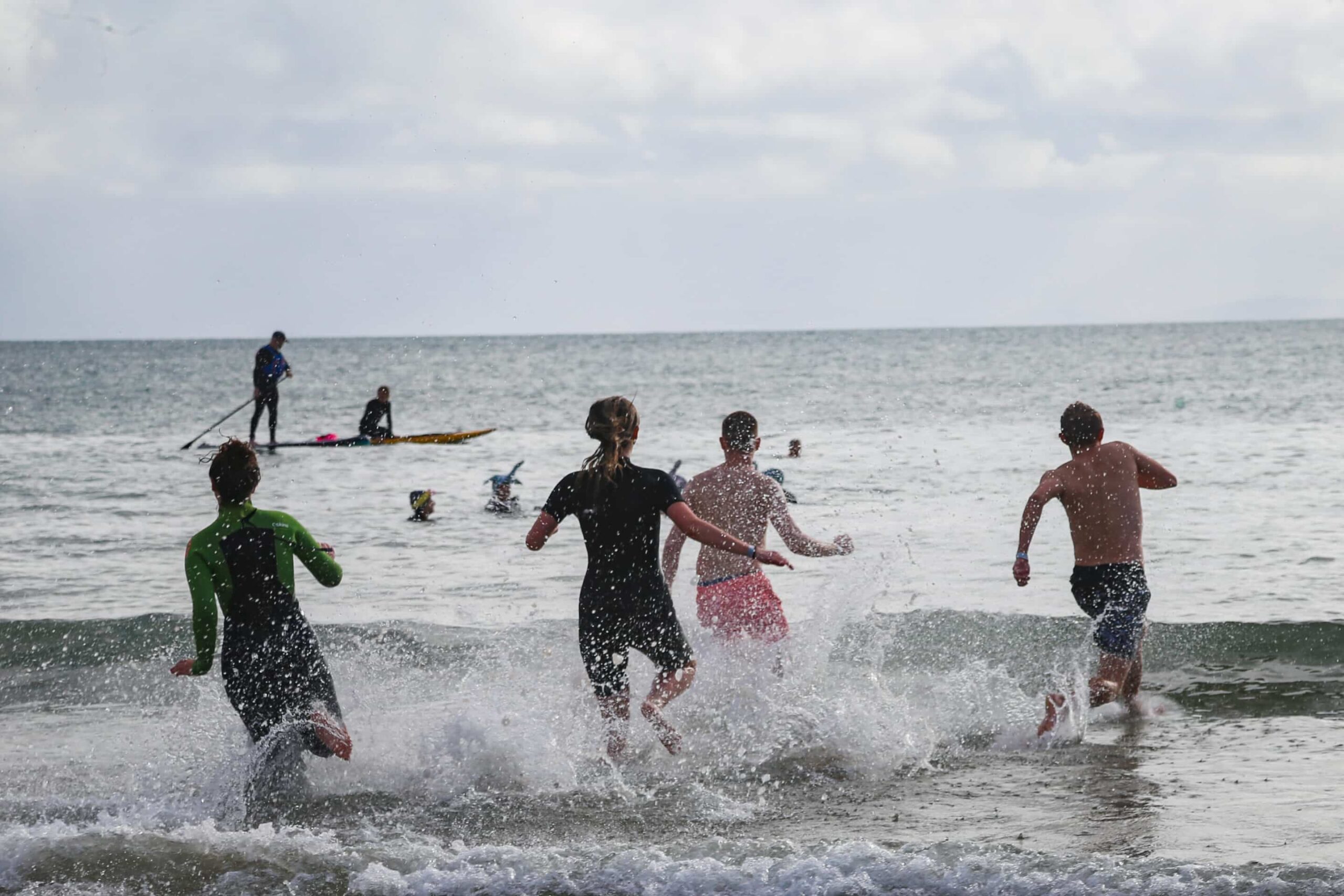 People running into the sea