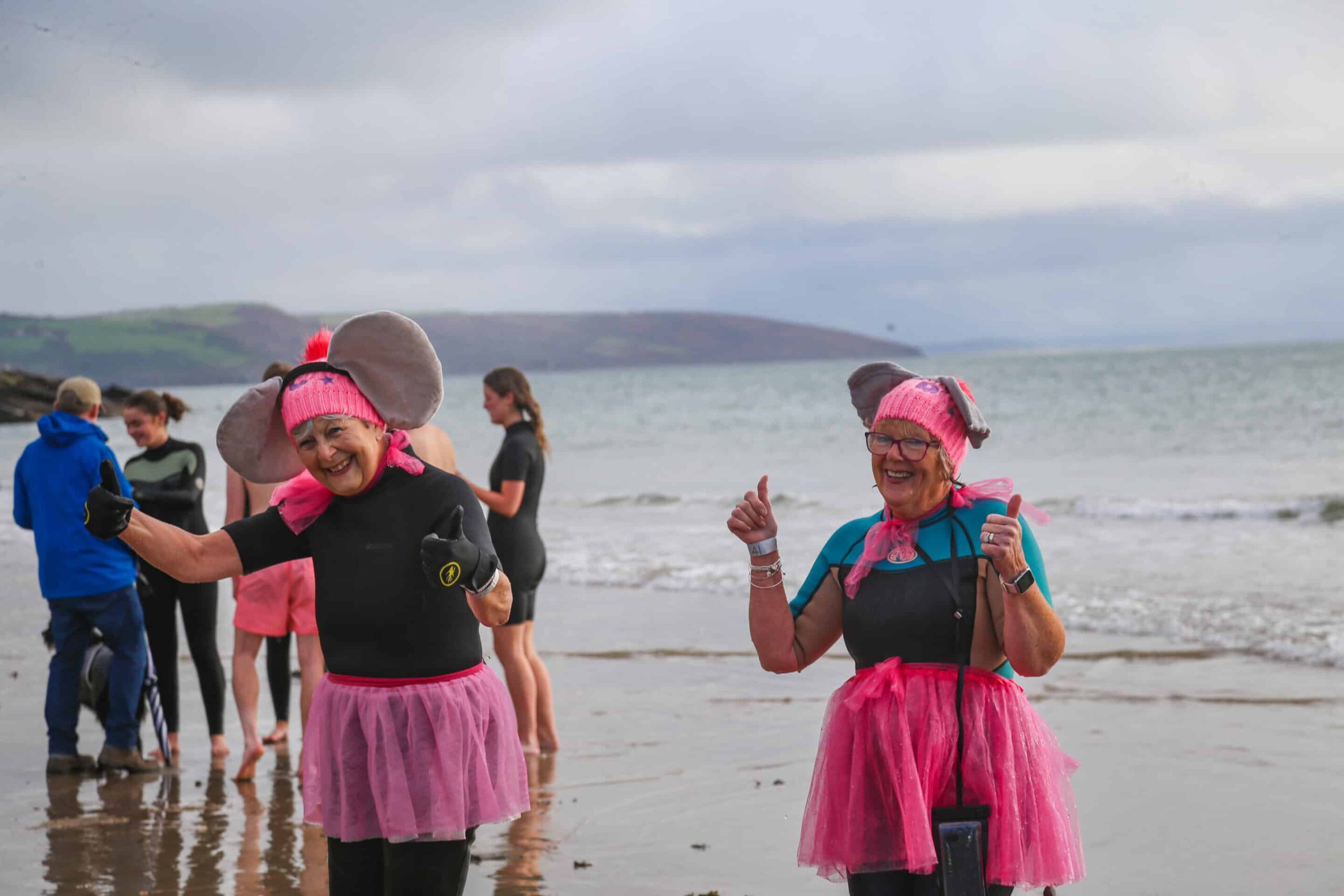 Women wearing pink skirts and elephant ears in the sea