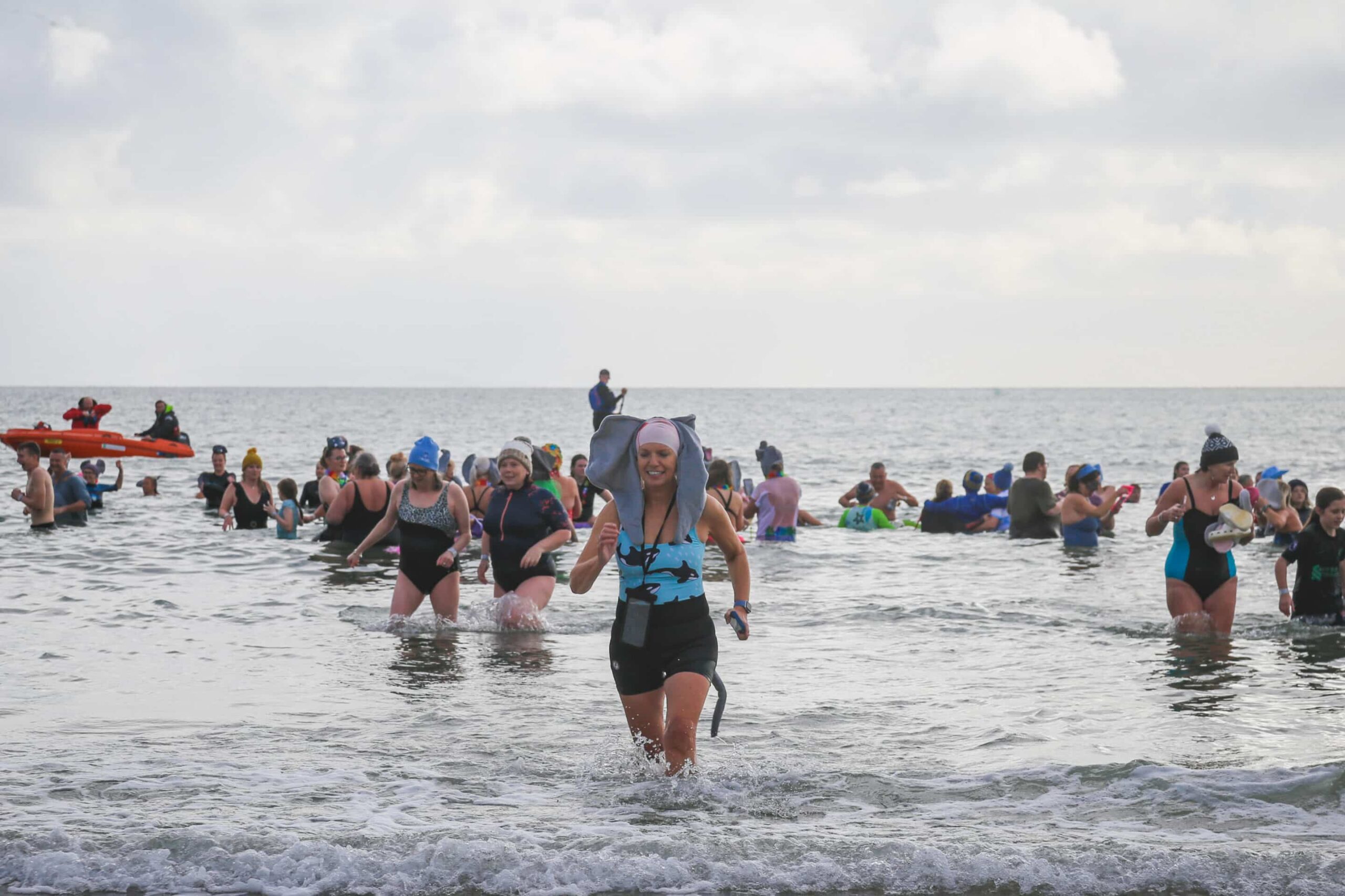 A group of people in the sea and one women wearing elephant ears